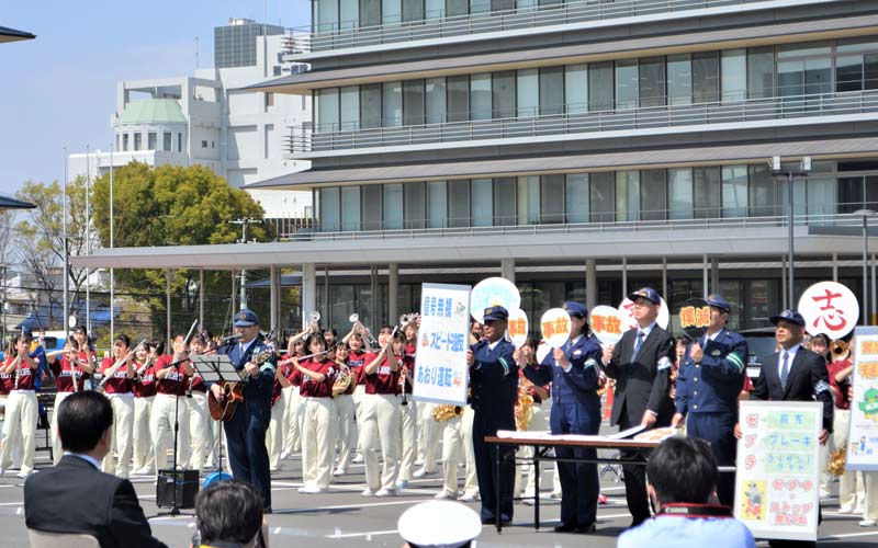 習志野署員らと一緒に、交通安全啓発の演奏を行う習志野高吹奏楽部＝９日、習志野市役所駐車場