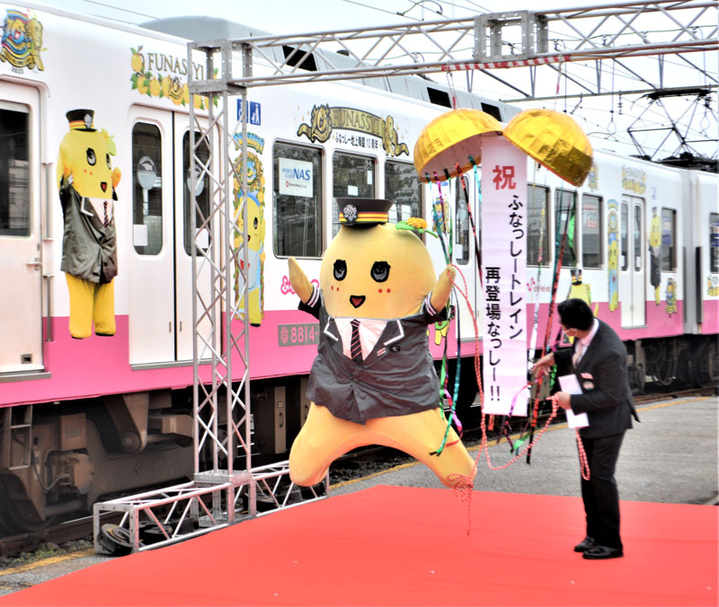 ふなっしーの“地上降臨”10周年を記念した新京成の特別塗装電車の披露式で、飛び跳ねて喜ぶふなっしー=20日、鎌ケ谷市のくぬぎ山車両基地