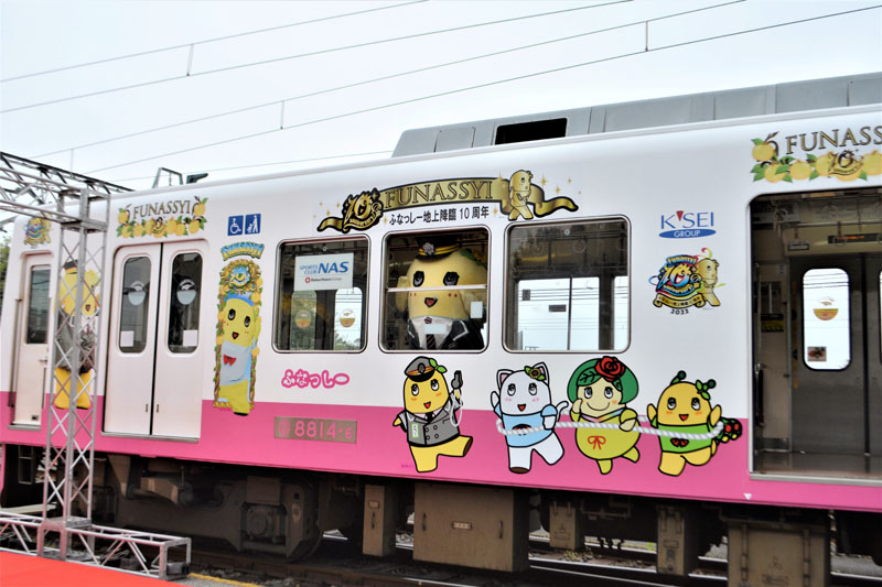 仲間たちも描かれた車両に乗り込むふなっしー。新京成の制服姿で登場した