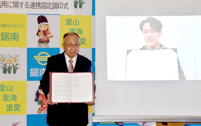 協定書を掲げる白石町長（左）と大林代表＝鋸南町役場