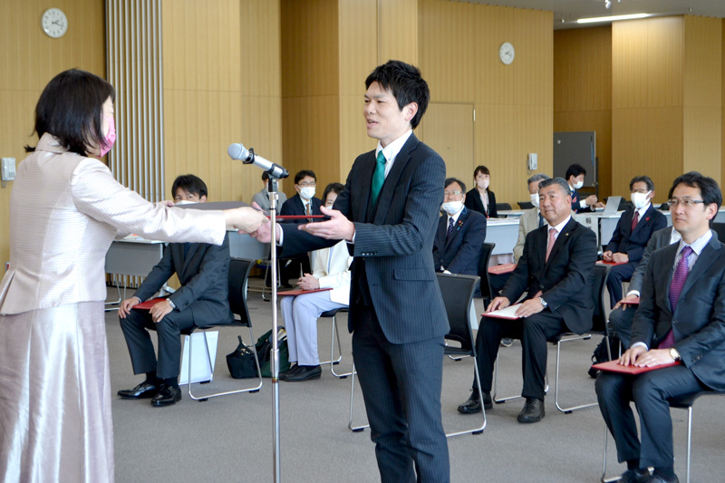 千葉市議選の当選証書を受け取る維新の山崎氏（中央）＝１０日、市役所