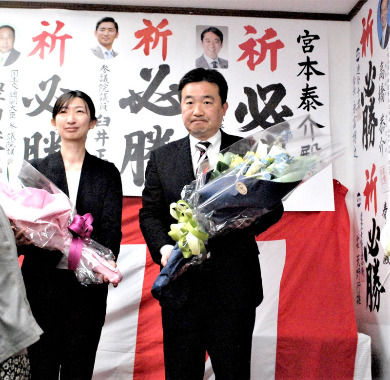 習志野市長に４選されて花束を受け取り、決意を新たにする宮本氏（右）＝２３日午後１１時１５分ごろ、同市