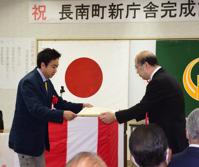 新庁舎建設に協力した事業者へ感謝状を贈る平野貞夫町長（右）＝２３日、長南町保健センター