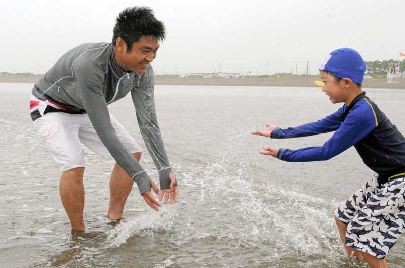 波打ち際で水遊びする家族連れ＝１日、九十九里町の片貝海水浴場