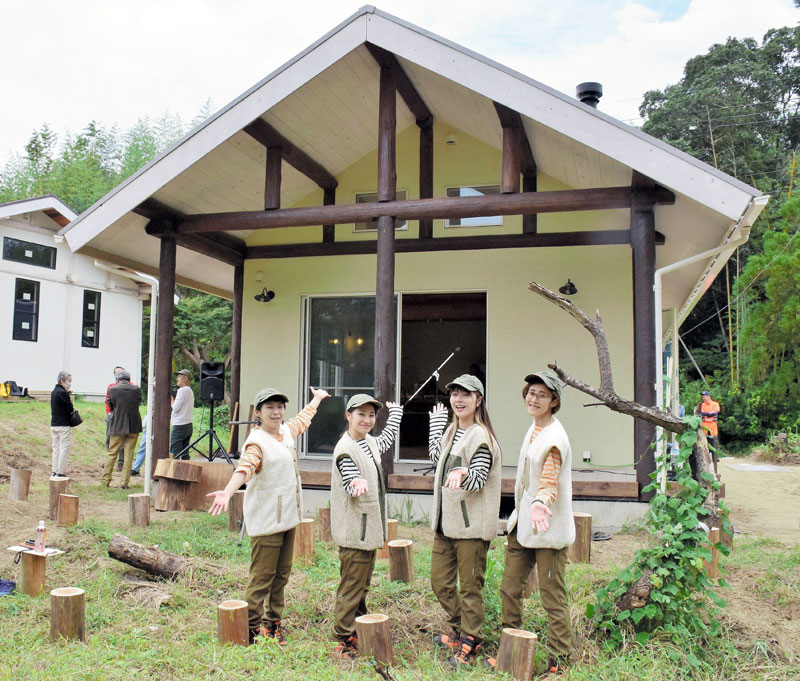 完成したログハウスをお披露目する4人=長柄町