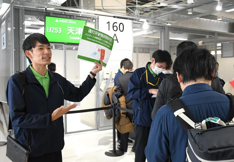 機内清掃業務から成田空港の地上係員に転身したJGSの雲野さん。第3ターミナルの搭乗口で中国に向かう旅客を案内している=成田市