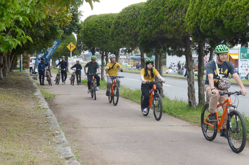 スポーツバイクの試乗体験会で県立蓮沼海浜公園近くの直線道路を走る観光客やガイドら