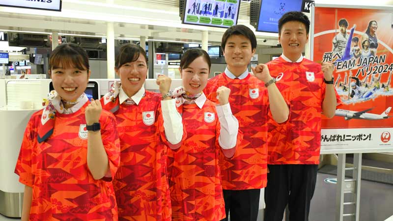 パリ五輪のレプリカユニホームを着用して出場選手へエールを送る成田空港の地上係員＝２６日、成田市
