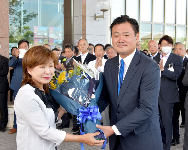 初登庁し花束を受け取る印西市の藤代新市長（右）＝２９日、市役所