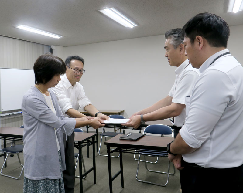 千葉県教育長宛ての要望書を県教委の担当者(右)に提出する浜野さん夫妻=4日、県庁