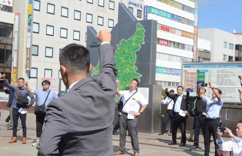 「頑張ろう」と気勢を上げる支援者ら＝１５日、習志野市