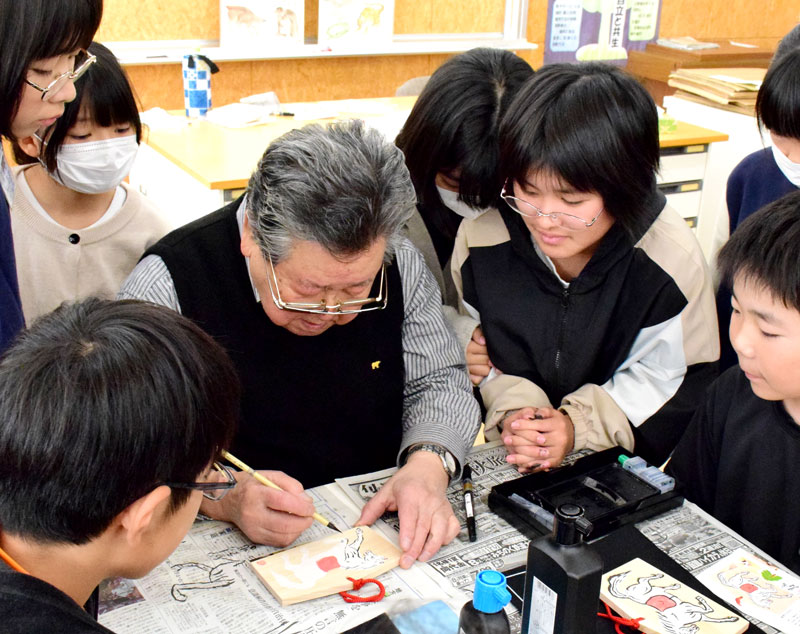 児童に絵馬の描き方を教える矢部さん＝２日、茂原市立本納小