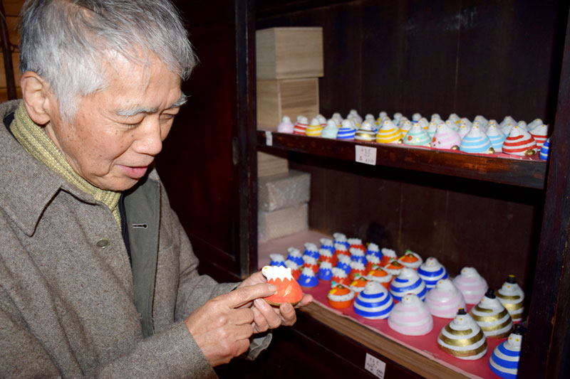 富士山の形にタカの羽とナスをあしらった「巳」を説明する千葉さん=13日、長南町