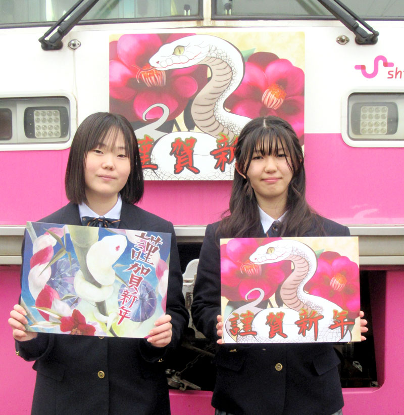 新年の干支にちなみ「蛇」のヘッドマーク絵を描いた松戸高校の窪田さん(左)と小野さん=新京成電鉄くぬぎ山車両基地