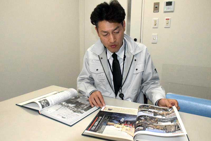 東日本大震災発生時に市の広報広聴班だった職員の石田さん。関わった広報誌や当時のメモ帳も開いて取材に応じてくれた＝１月、旭市
