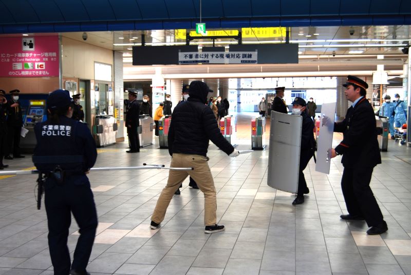 訓練で犯人の制圧を試みる駅員と流山署員=流山市の東武野田線流山おおたかの森駅