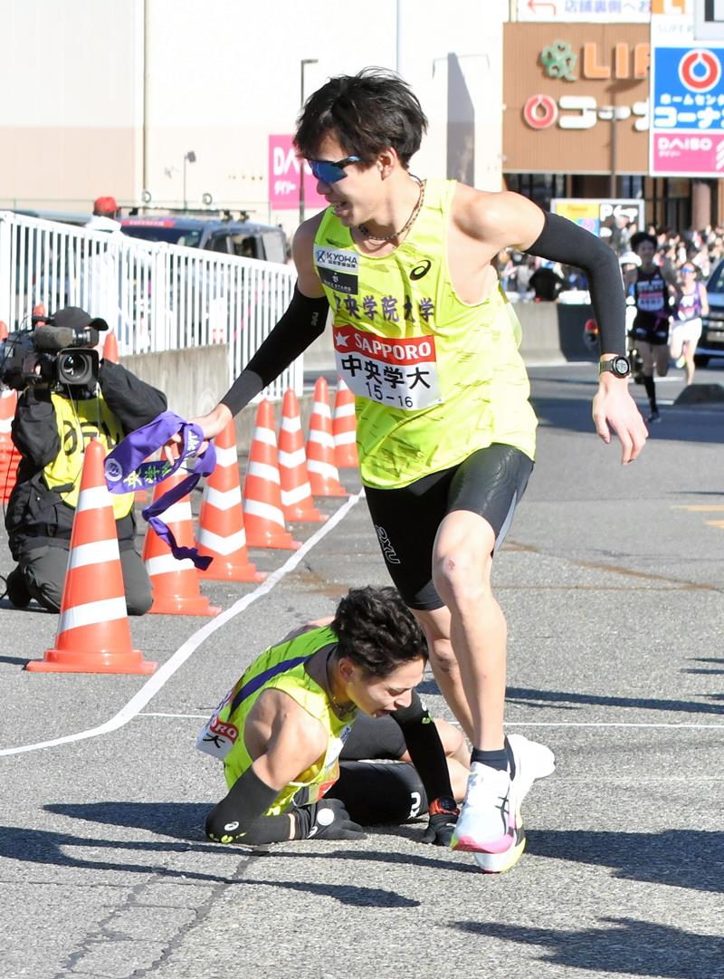倒れ込みながらたすきを渡した中院大の2区吉田礼志(奥)と駆け出す3区の市川大世=横浜市戸塚区