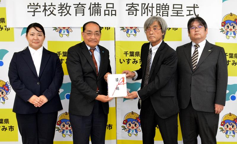 神保電器から学校教育備品寄付の目録を受け取る太田市長（左から２人目）＝いすみ市役所
