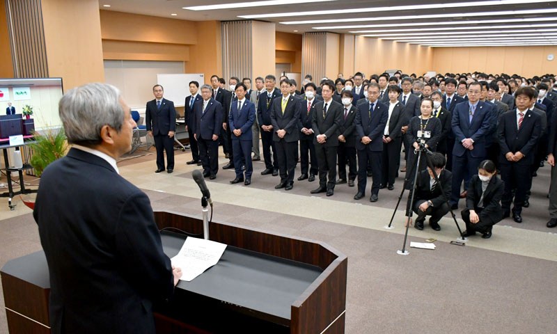NAAの仕事始め式で田村社長のあいさつを聞く社員=6日、成田市