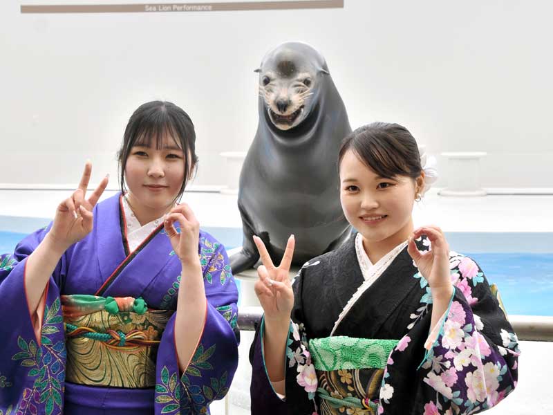 “笑うアシカ”の「カンジ」と一緒に笑顔を浮かべる「二十歳の集い」の参加者=12日、鴨川市