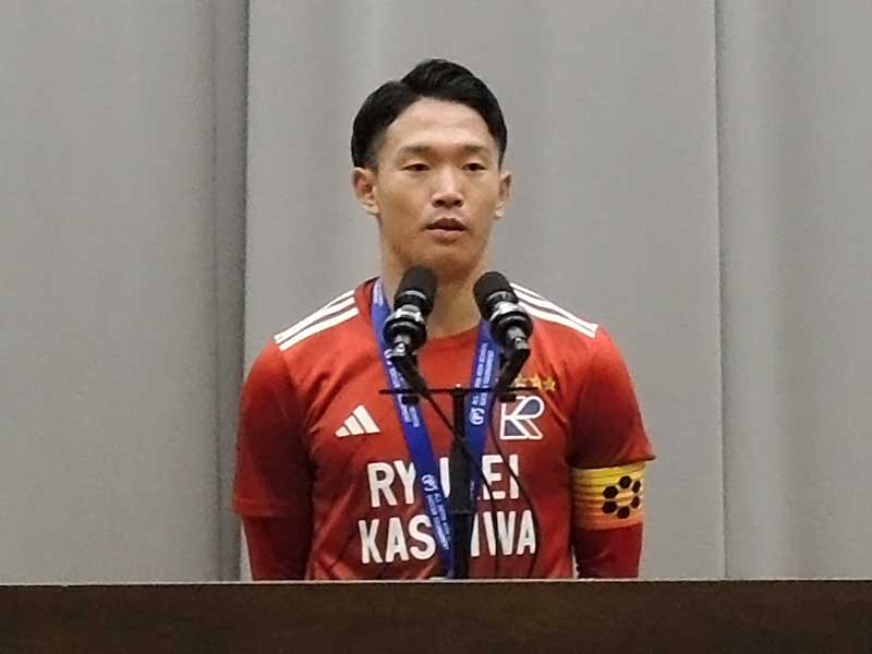 流通経大柏高校で開かれた準優勝報告会であいさつするサッカー部の佐藤主将=15日、柏市