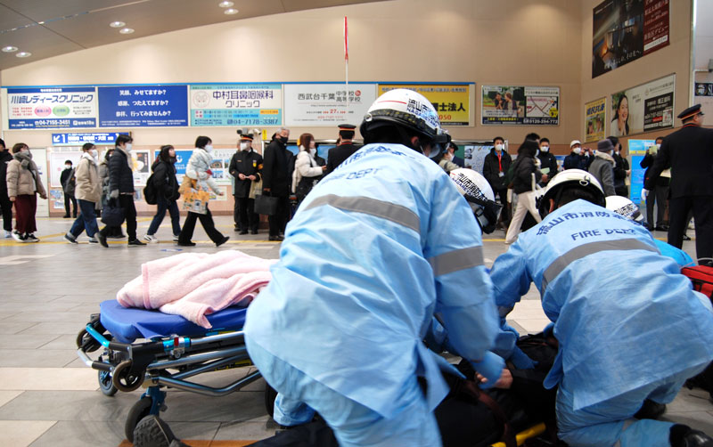 乗客が行き交う中、訓練で重傷者の救護を行う流山市消防本部の救急隊員