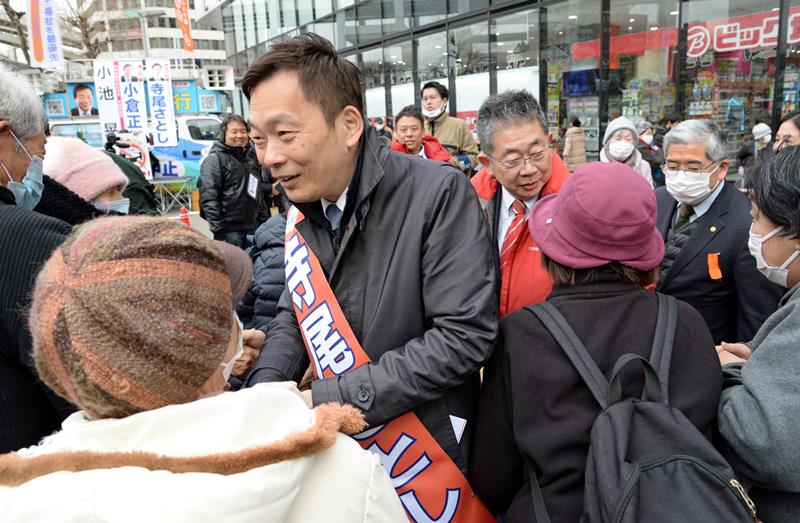 街頭演説を終え、共産党の小池書記局長（中央右）と共に支持者と握手する寺尾氏（中央）＝８日、ＪＲ千葉駅前