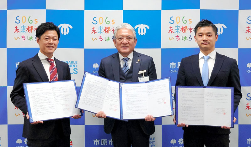 協定書を手にする川口CEO(左)と河田社長(右)。中央は小出譲治市長=市原市役所