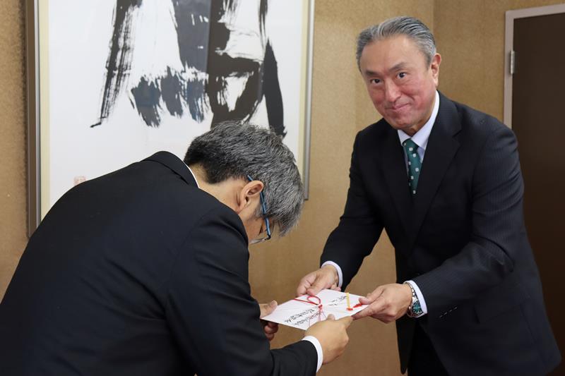 寄付目録を手渡す市原会長（右）