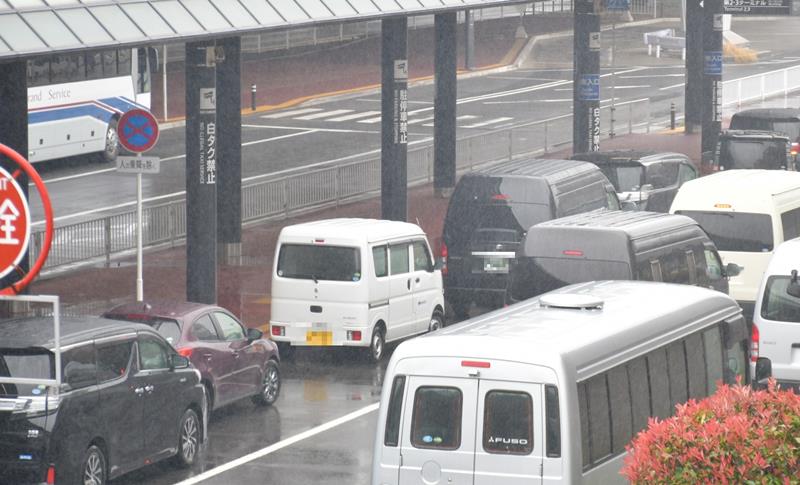 縦列駐車する車で混雑する成田空港の乗降場。支柱に「駐停車禁止」との大きな表示もあるが、走行レーンにまで車があふれている=2日午後、成田市(画像を一部加工しています)