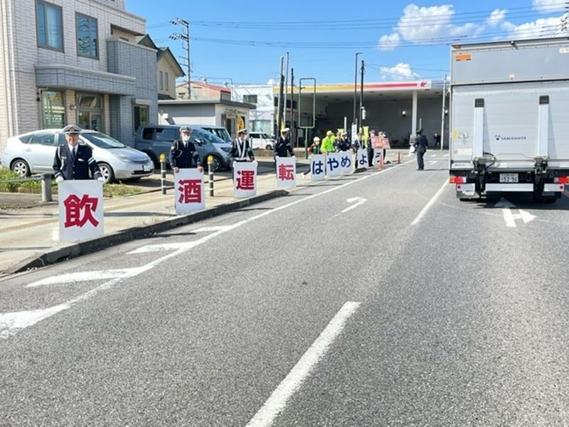 佐倉署の啓発活動で飲酒運転根絶に向けたプラカードを掲げる関係者=4日、八街市(同市提供)