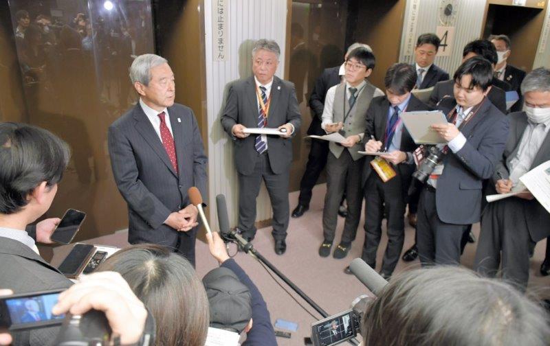 報道陣に囲まれる中で成田空港の滑走路新設など機能強化工事の本格着工について説明するＮＡＡの田村社長（左奥）ら＝４日、東京都千代田区の国土交通省