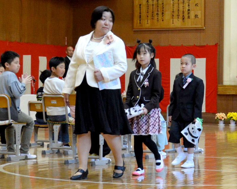 勝浦市立興津小の入学式に出席した新1年生の2人。在校生13人が温かく迎えた=9日、勝浦市