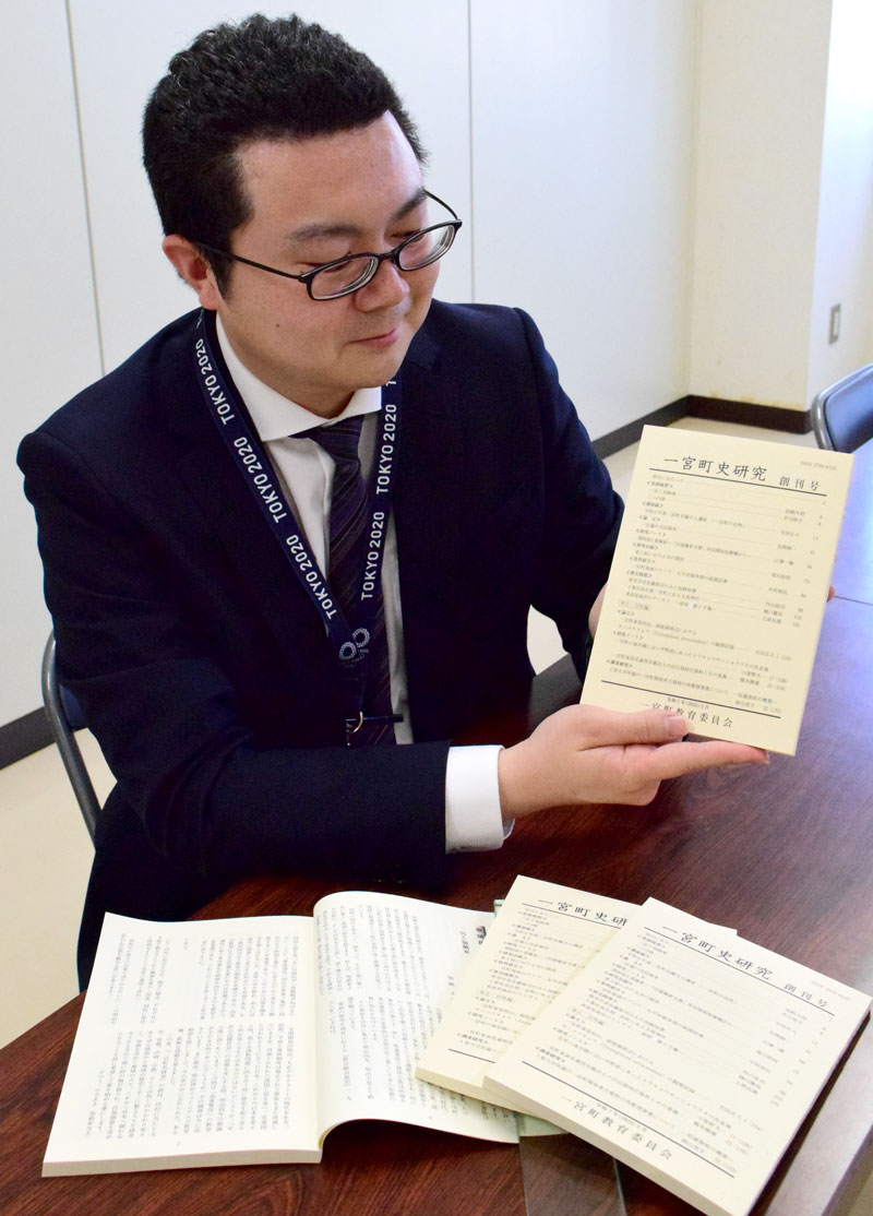 「一宮町史研究」の創刊号を持つ担当者＝同町