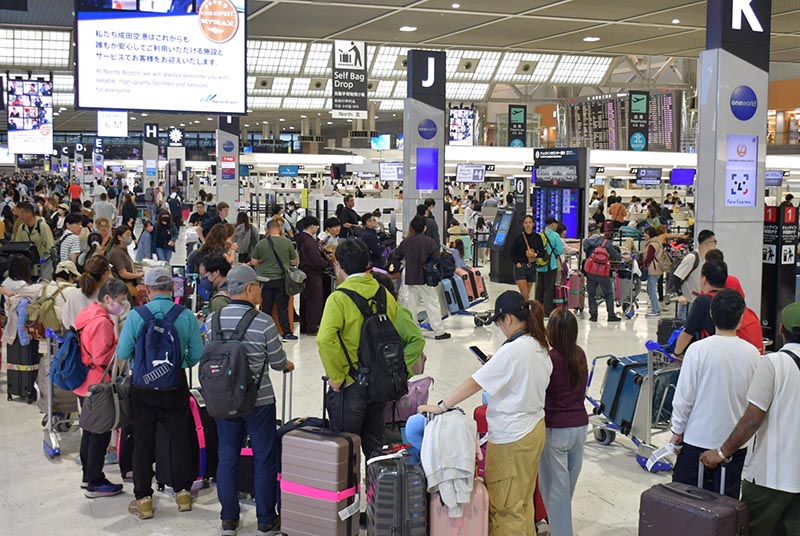 国際線の搭乗手続きを待つ長い列ができた成田空港第2ターミナル=25日午後、成田市