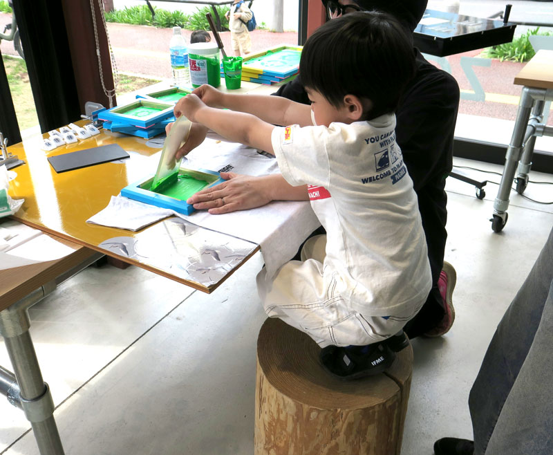 服に絵柄をプリントするシルクスクリーンを体験する子ども＝４日、千葉市稲毛区のＺＯＺＯ本社敷地内