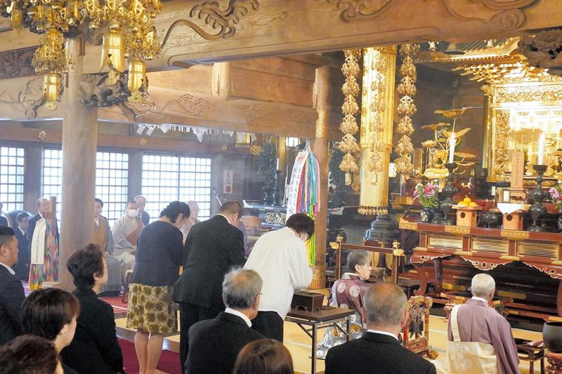 先祖法要で静かに手を合わせる参列者＝６日、銚子市