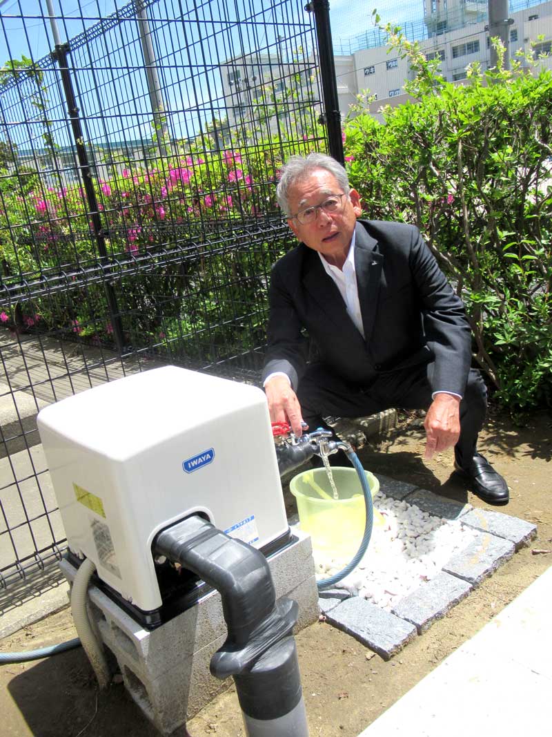 設置された災害用井戸から水を出す今野組合長=市川市