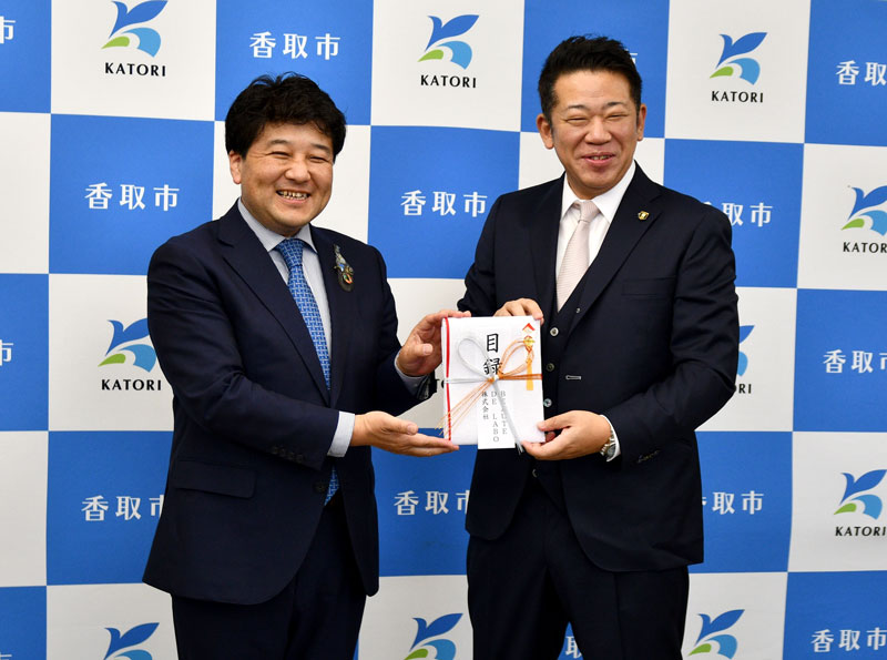 伊藤市長（左）に目録を手渡す渡辺社長＝香取市役所