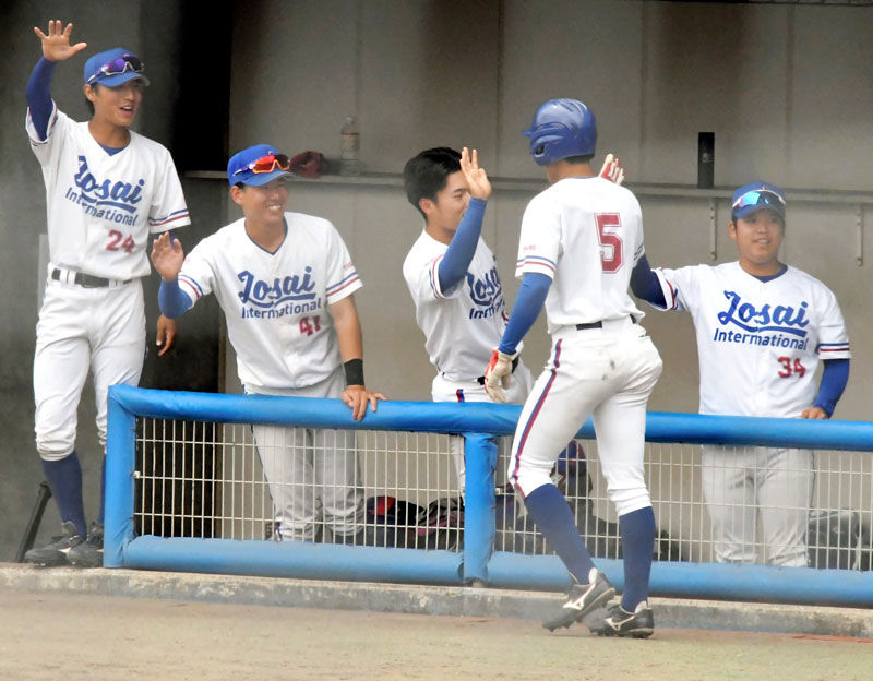 城国大-千経大2回戦 6回裏城国大2死二塁、田中陽の適時打で生還した幸鉢(5)を笑顔で迎える選手ら=19日、長生の森