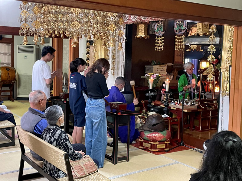 読経が流れる中焼香し手を合わせる参列者=25日、市原市の龍善院