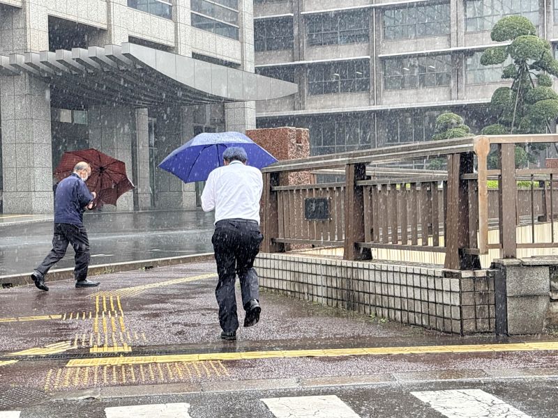 強い雨が降る中、傘を差して歩く通行人＝２日、千葉市中央区の県庁前