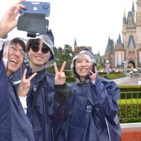 ４０周年のデコレーションが施されたシンデレラ城と写真に収まるゲスト